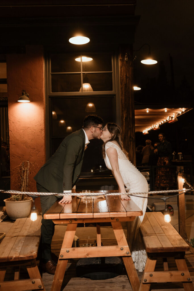 bride and groom kiss during their minimony wedding reception outside at denver restaurant.