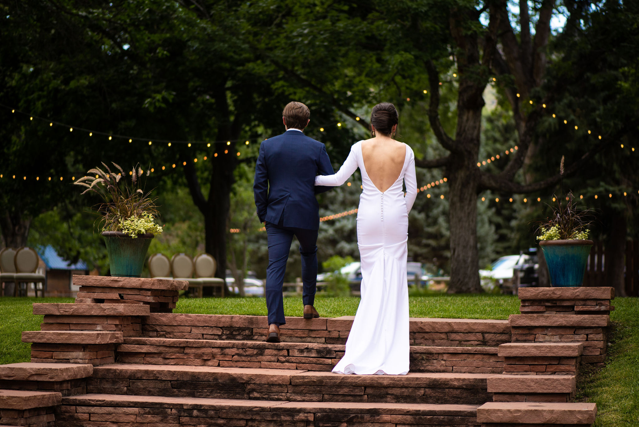 bride and groom walk up steps during their colorado micro wedding at river bend venue.