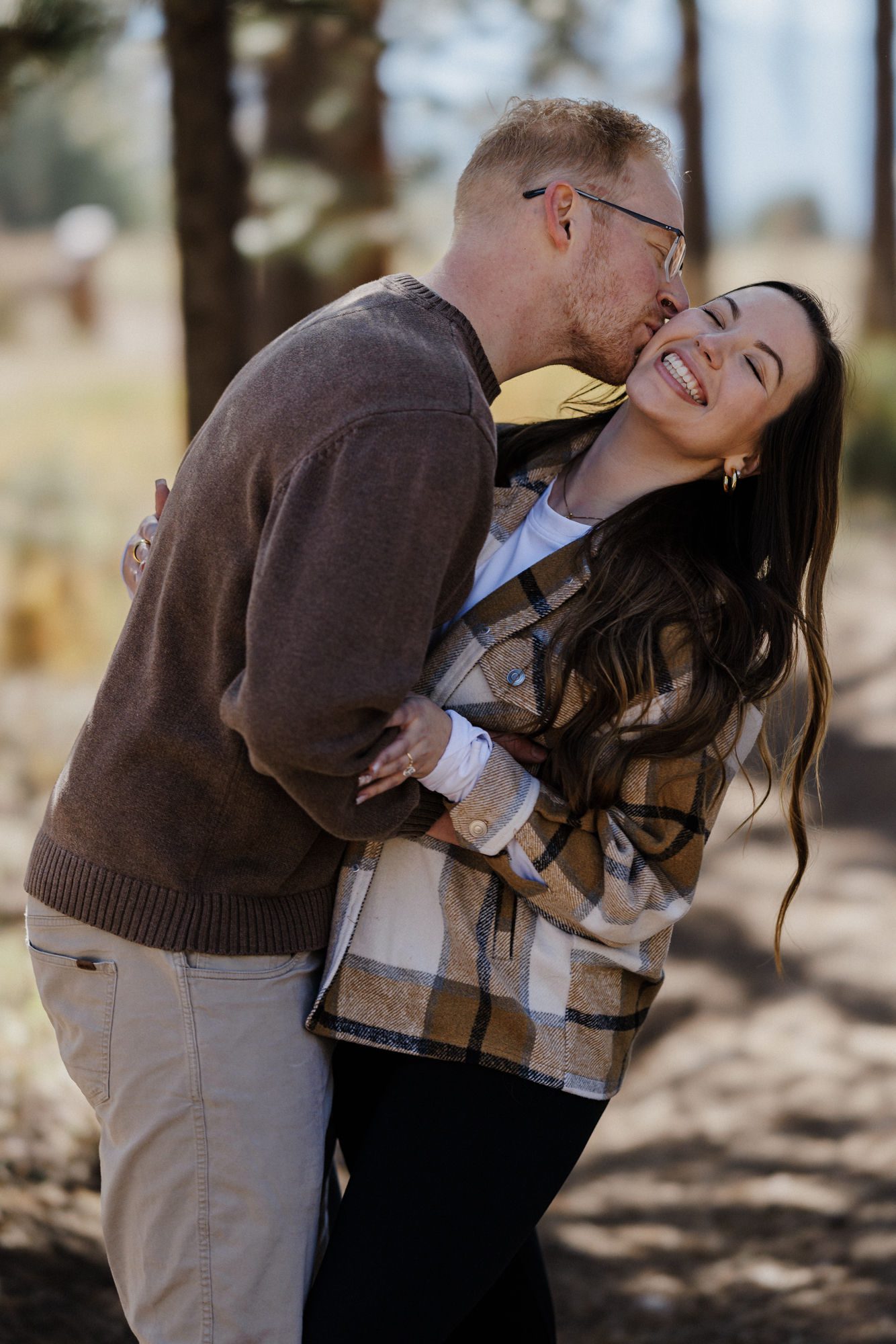 man and woman smile and laugh after their colorado mountain proposal.