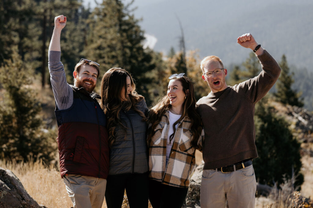 group of friends cheer after a surprise colorado proposal.