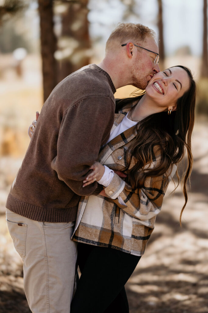 man and woman smile and laugh after their colorado proposal.