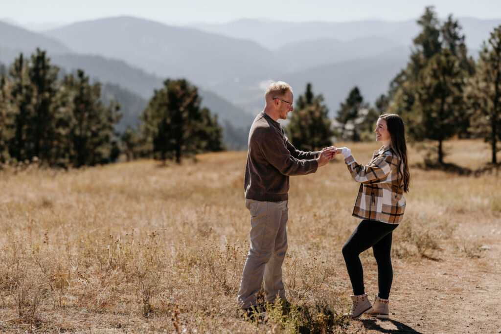 man puts engagement ring on woman during colorado proposal.