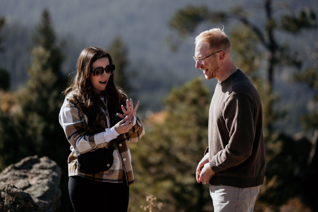 man and woman admire new engagement ring after colorado proposal.