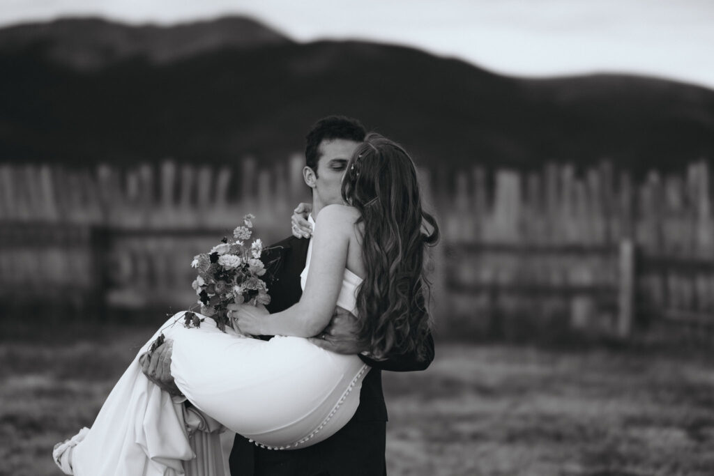 groom picks up bride and kisses her duiring colorado wedding.