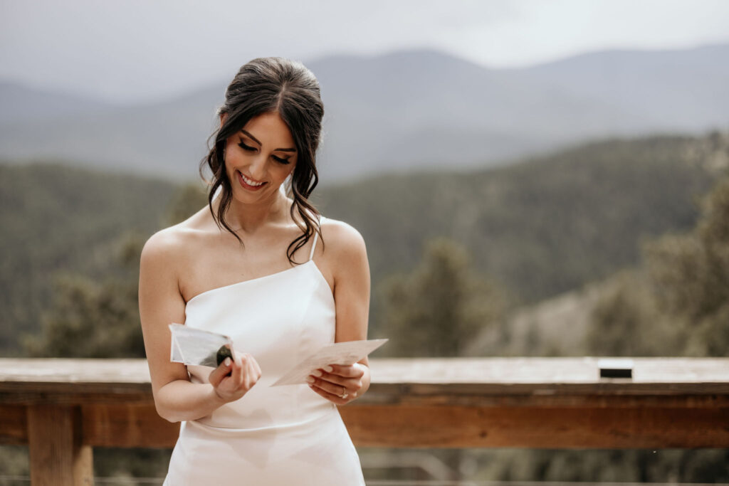 bride smiles and reads personal letter from husband during their micro wedding.
