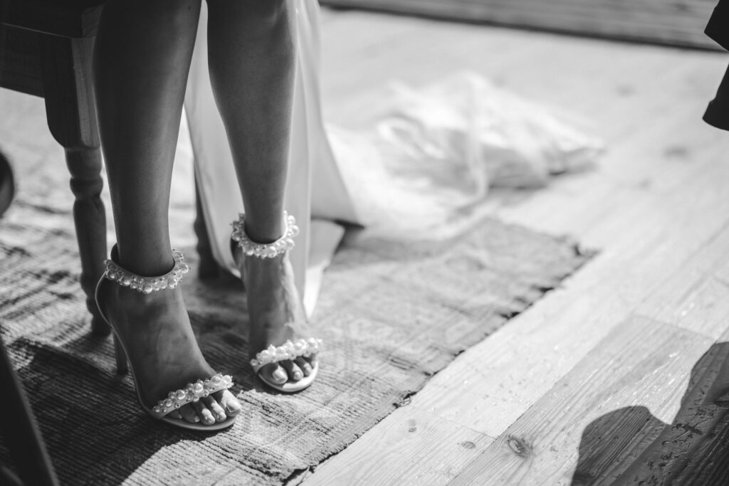 black and white close up image of a brides pearly wedding shoes.