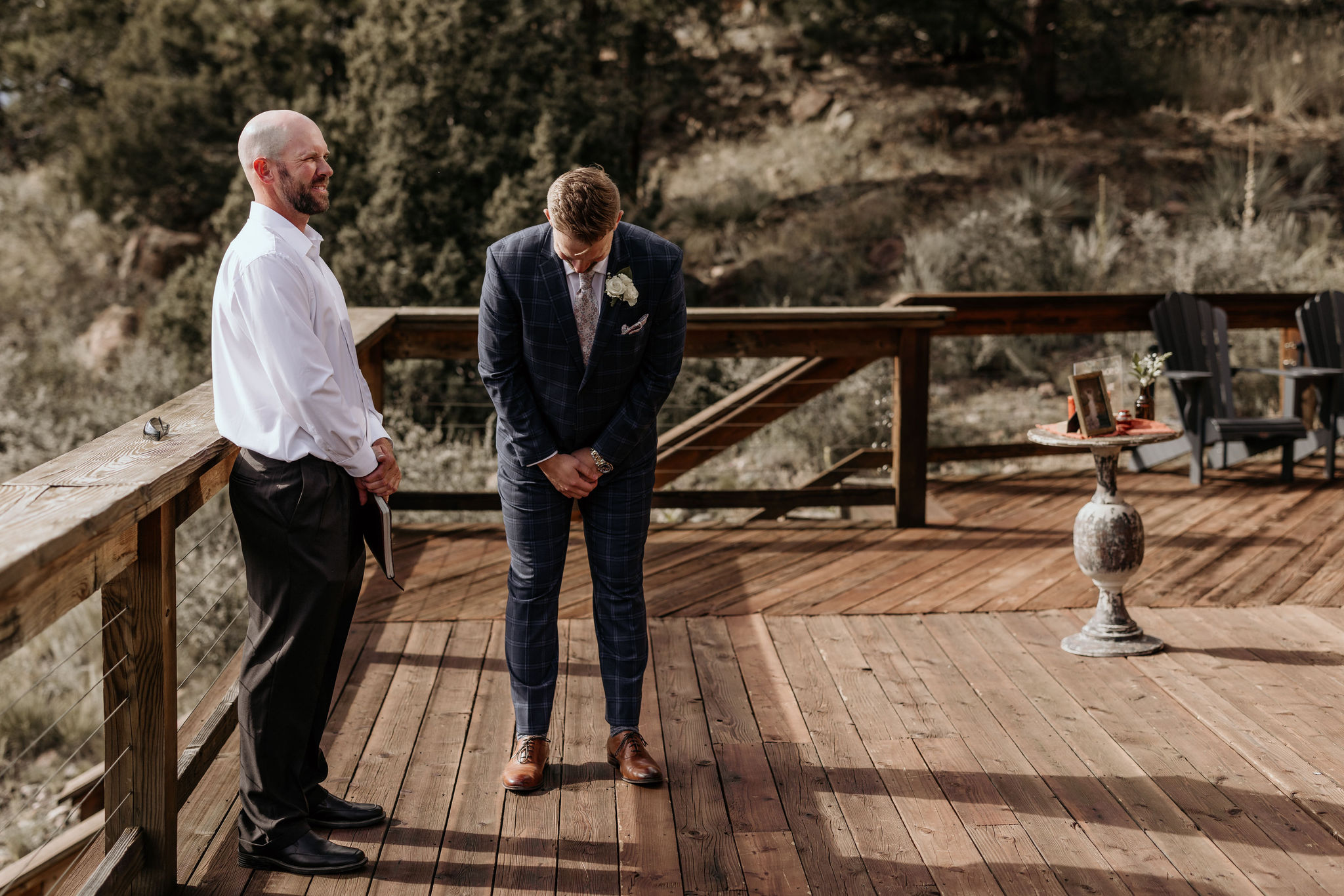 groom stands on the deck of their rental home, waiting for his bride.