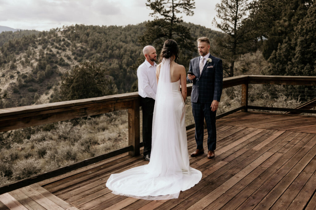groom reads self-written vows from phone during colorado micro wedding.