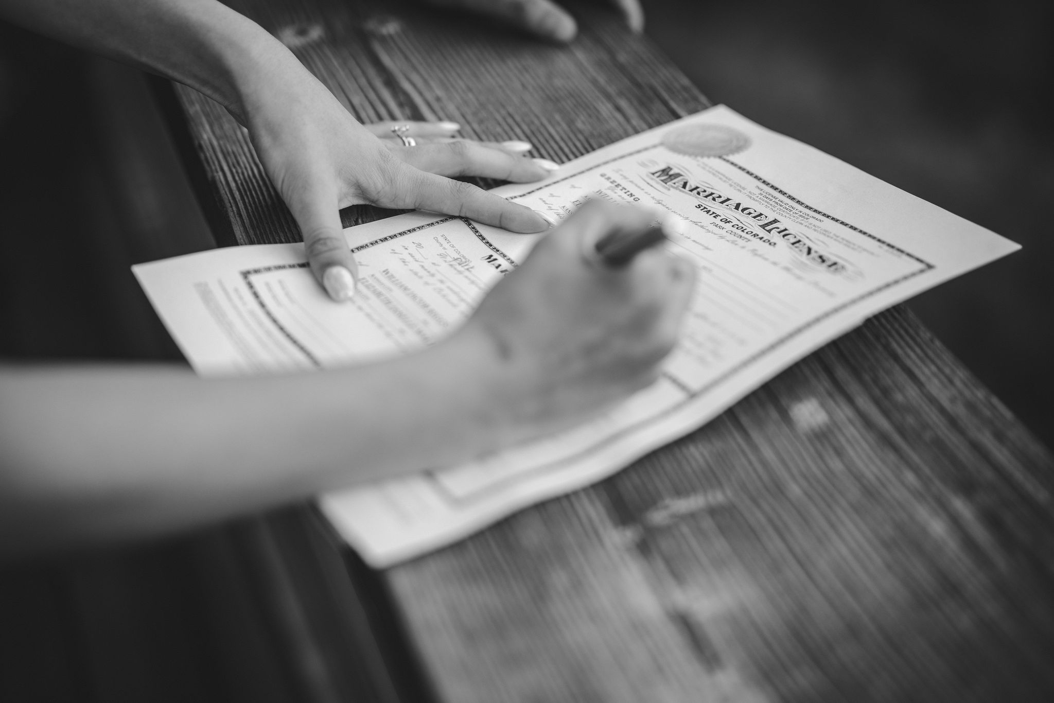 bride signs marriage certificate during her colorado micro wedding.