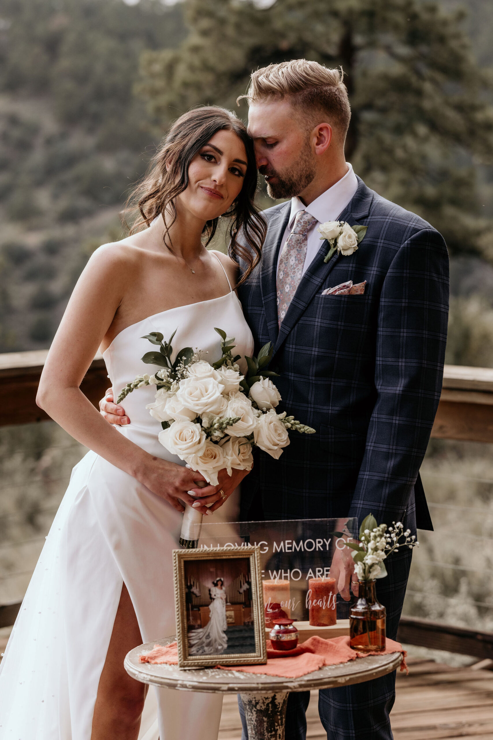Bride and groom stand by memorial table of their loved one.
