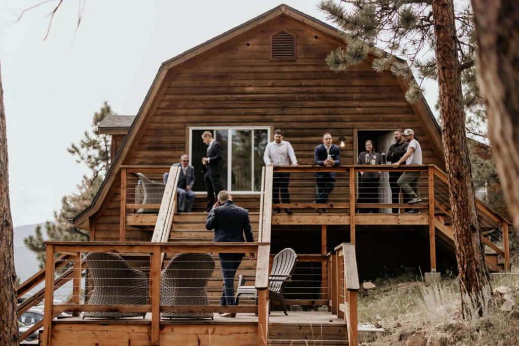 wedding guests hang out on the decks of a colorado airbnb.