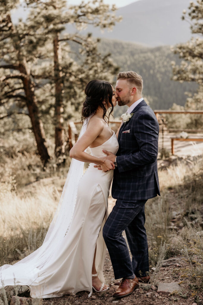 bride and groom kiss in the colorado mountains during micro wedding.