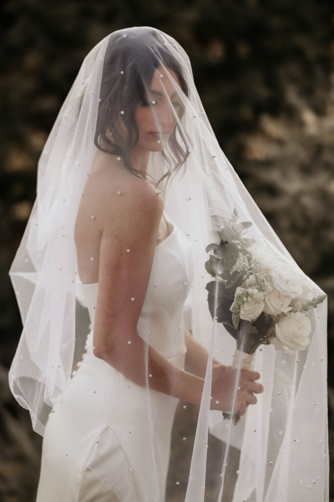 bride poses under veil for colorado elopement photographer.