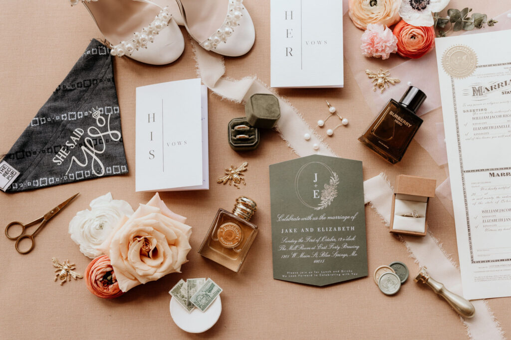 close up image of wedding details: wedding shoes, wedding stationary, vow books.