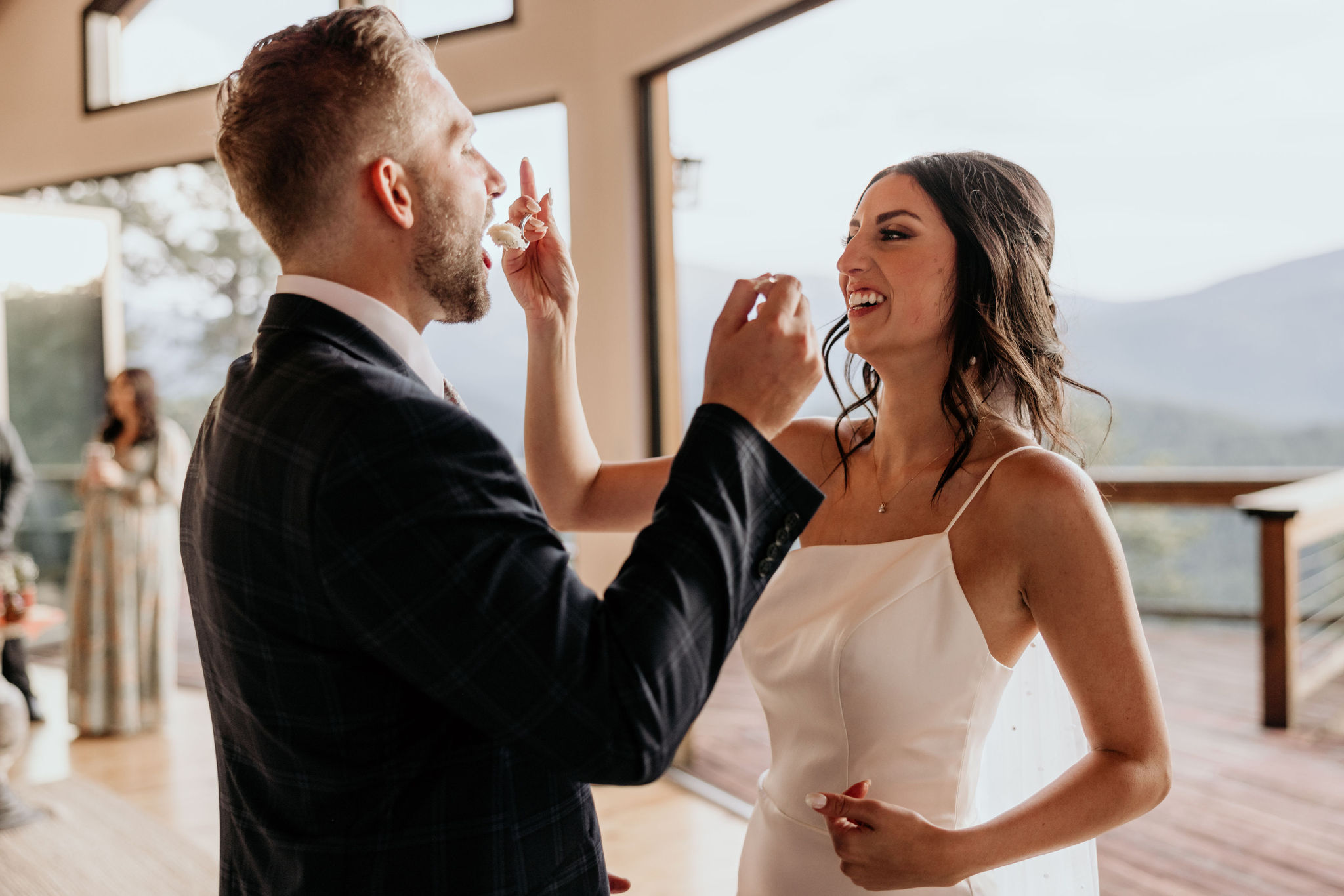 bride and groom feed each other cake during reception.