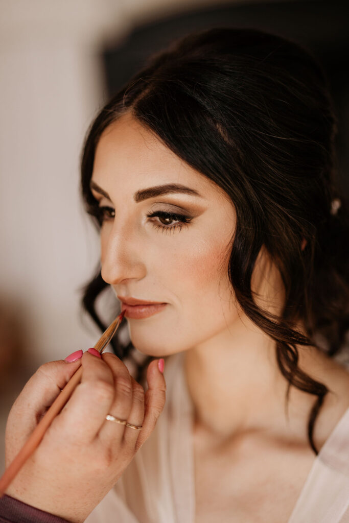 close up image of bride getting her wedding makeup done.