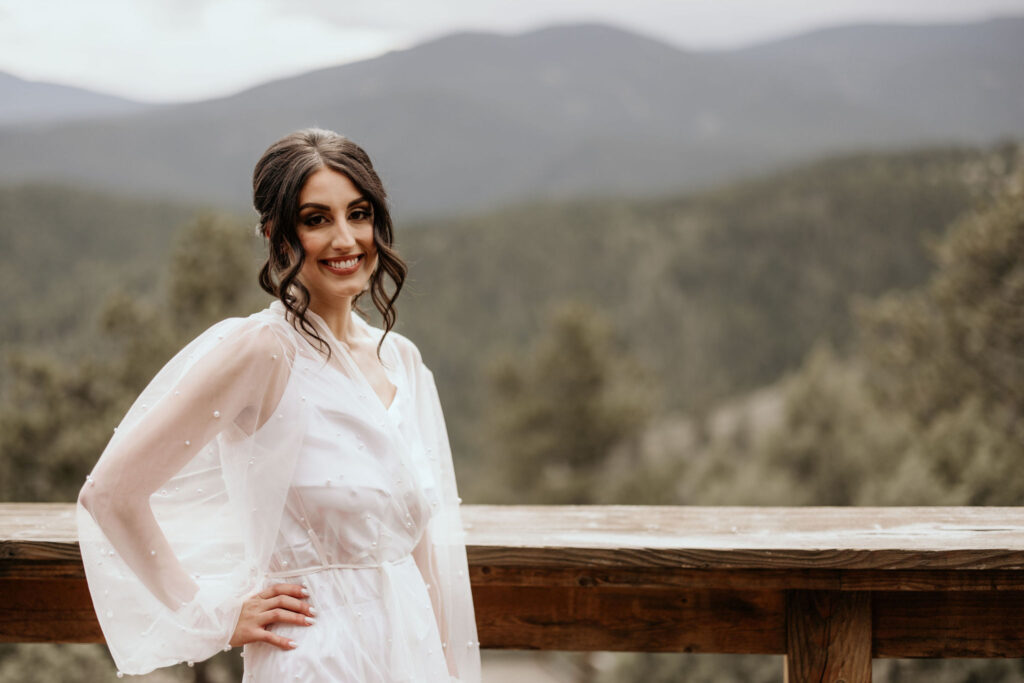 bride poses for micro wedding photographer on the deck of an airbnb.