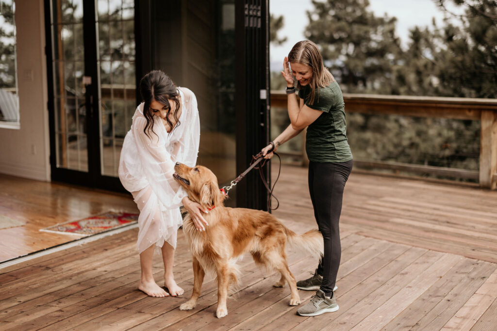 bride pets her dog on the deck of an airbnb.