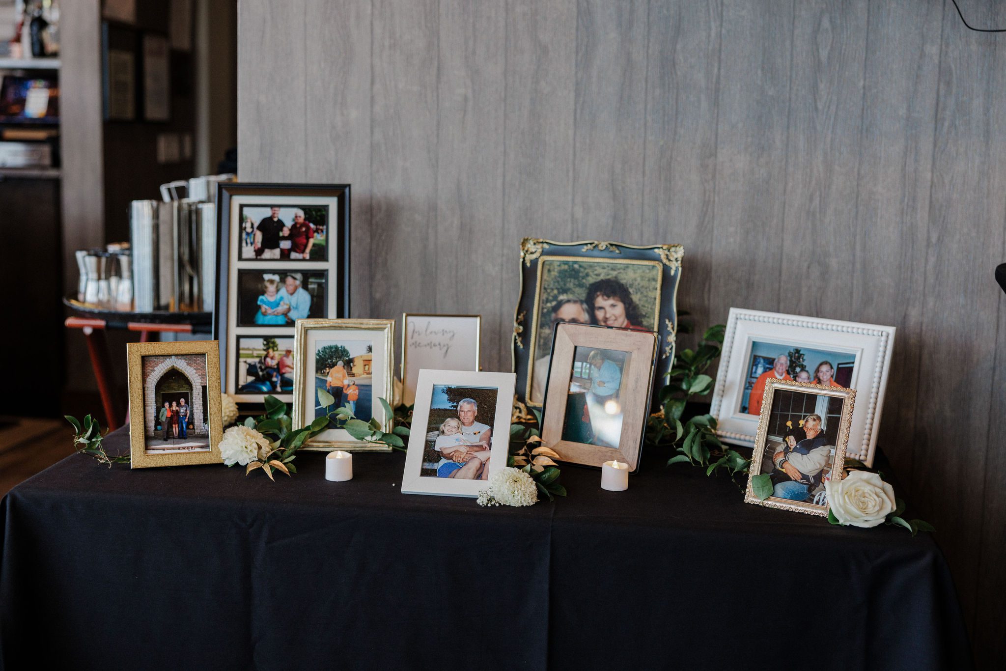memorial photos sit on a table after planning a wedding while grieving.
