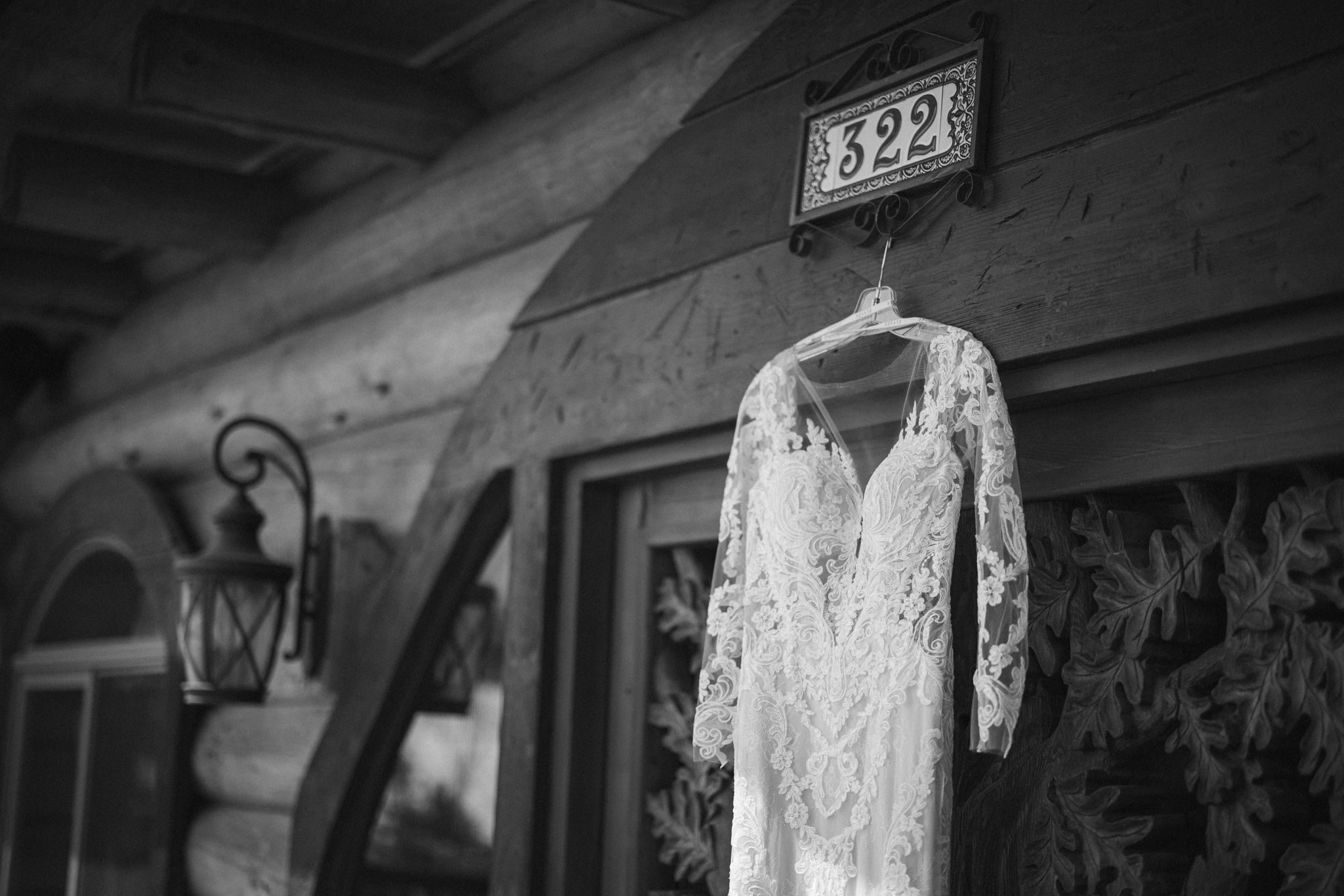black and white photo of wedding dress hanging on the door of an airbnb