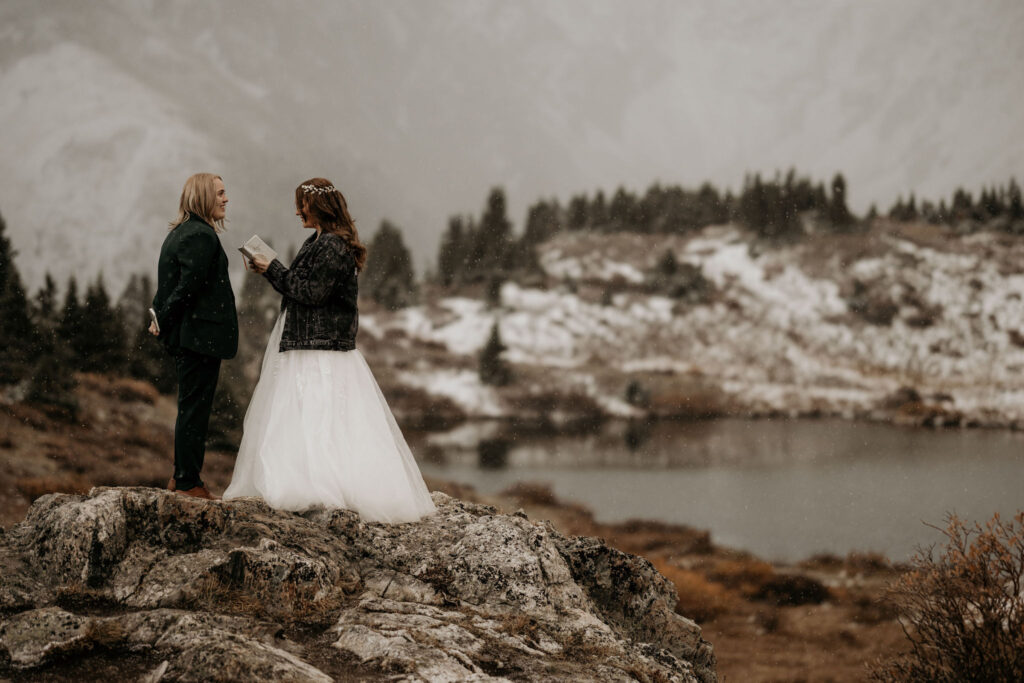 newlywed couple stand on rock at Loveland Pass Lake during their breckenridge colorado elopement.