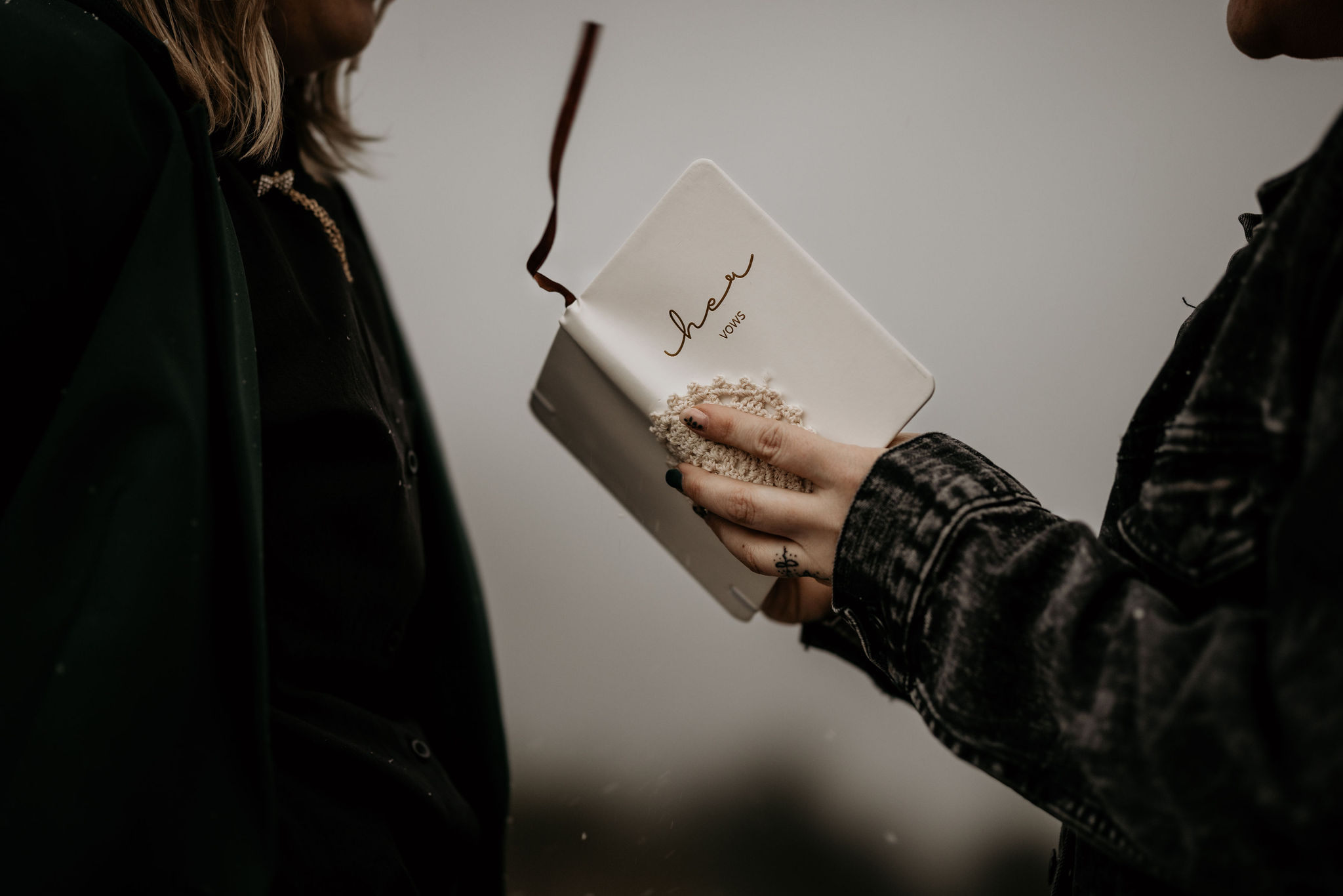 close up image of person holding their vow book during their colorado elopement.