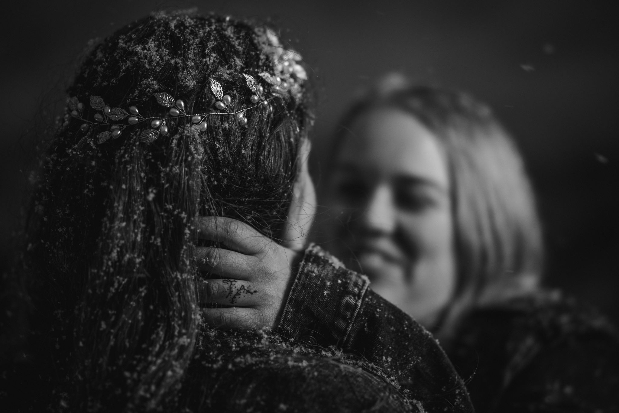 person puts hand on spouses neck during snowy wedding photos in colorado.