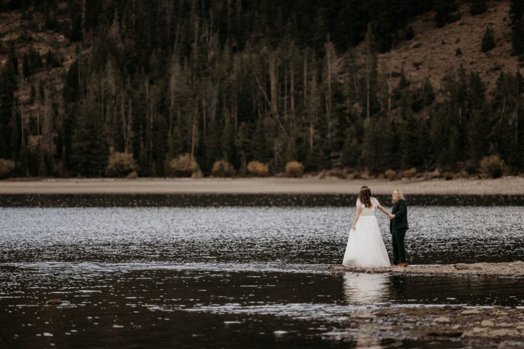 newlywed couple stand on the shore of lake dillon during their LGBTQ+ elopement photos.