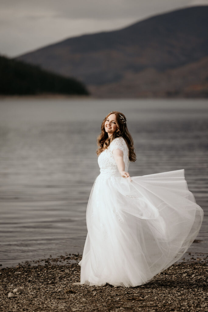 bride twirls dress during breckenridge elopement at Dillon Reservoir.