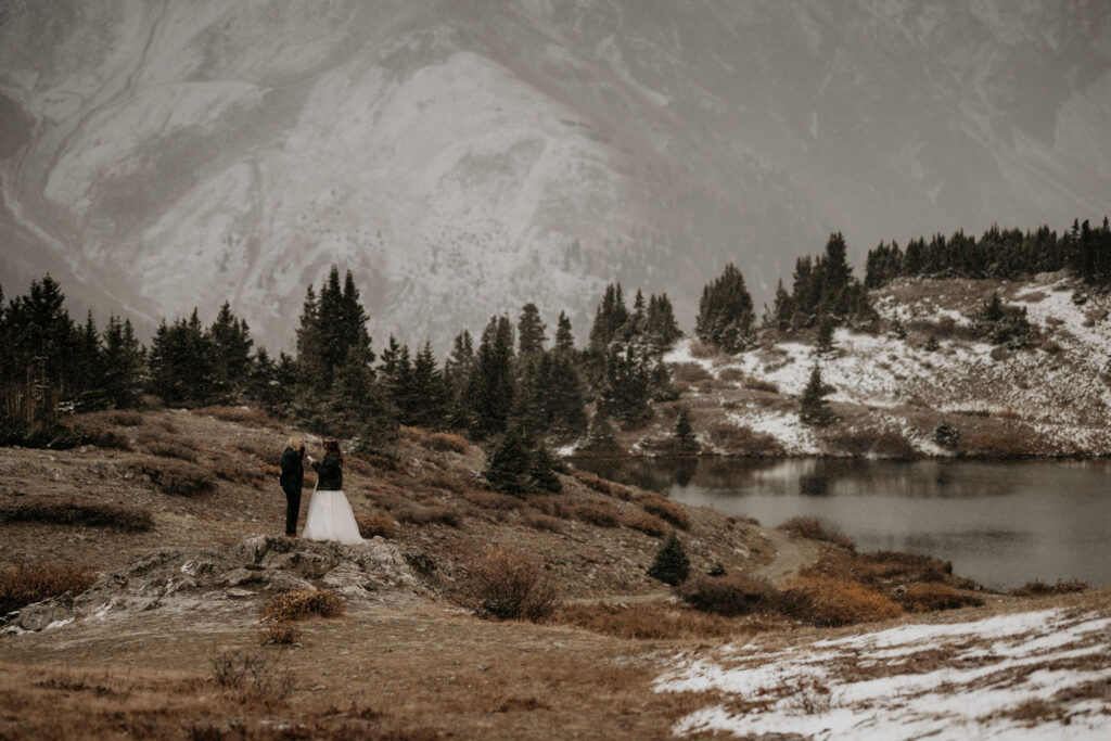 newlywed couple stand on rock and say self-written vows during their breckenridge colorado elopement