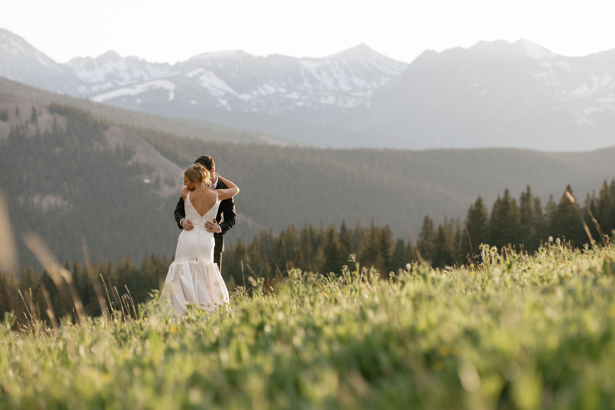 bride and groom dance in the sunset in the mountains after planning a wedding while grieving