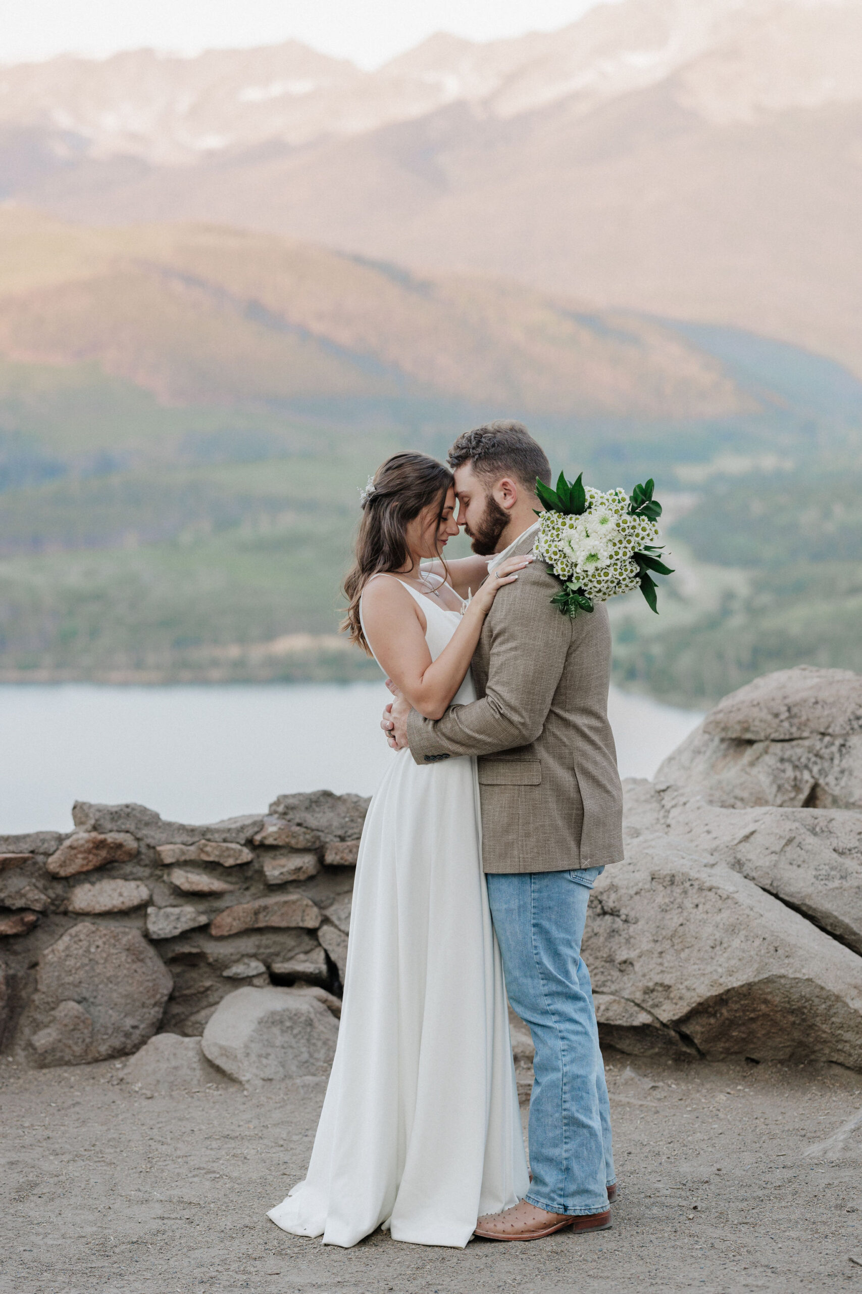 bride and groom stand with heads together after elopement ceremony in colorado