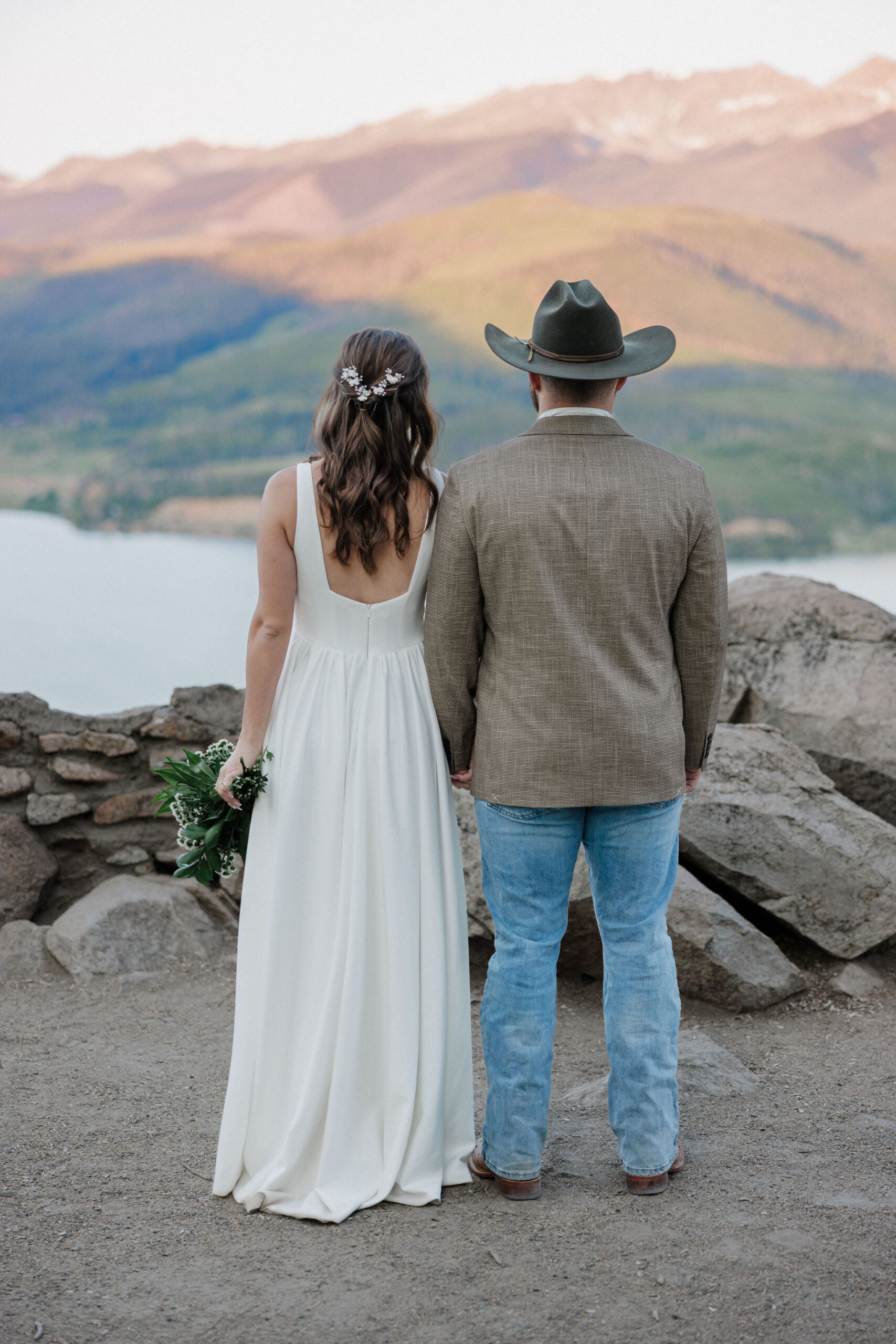 bride and groom look out at the colorado mountains after elopement ceremony