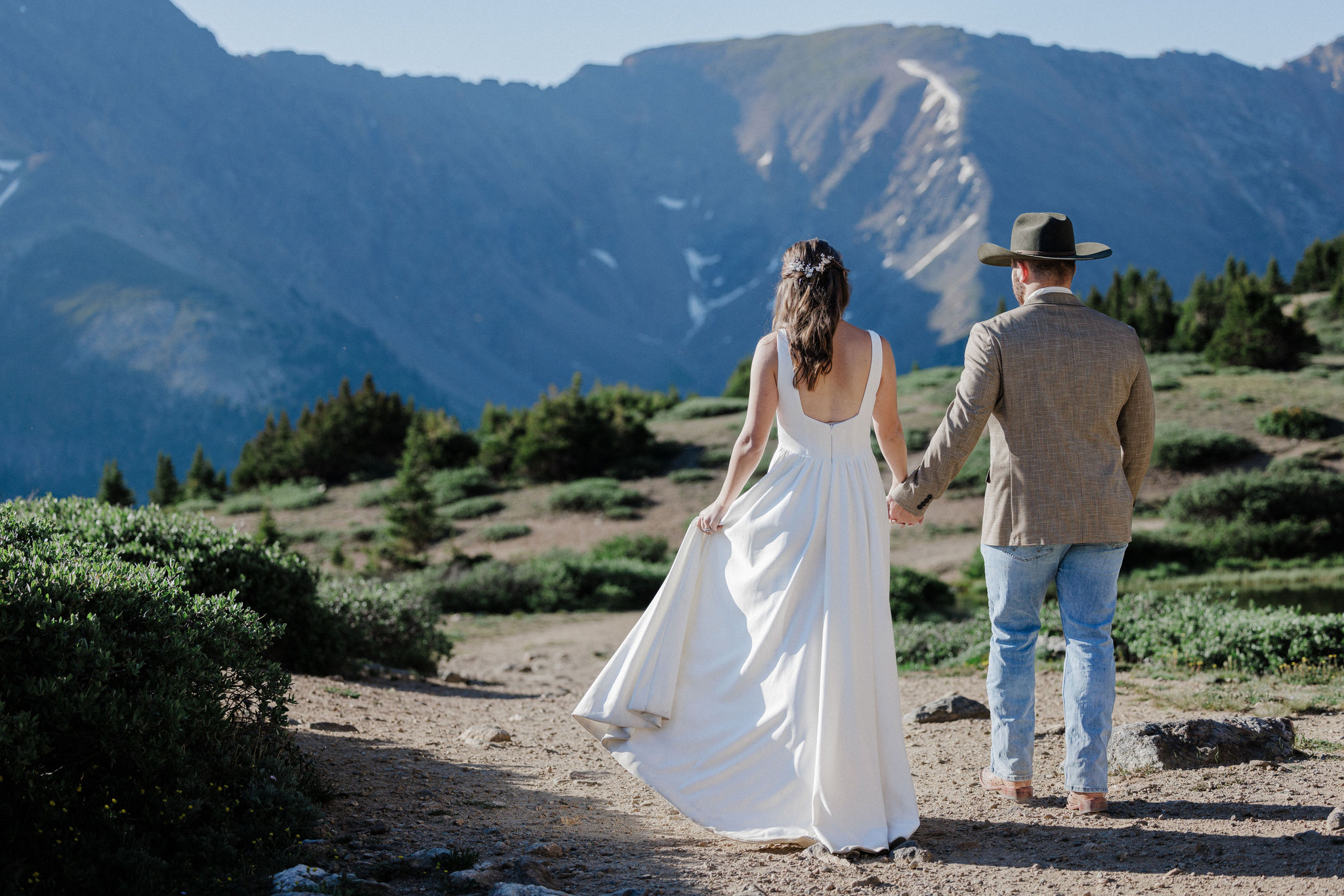 bride and groom run up mountain at colorado elopement location in breckenridge