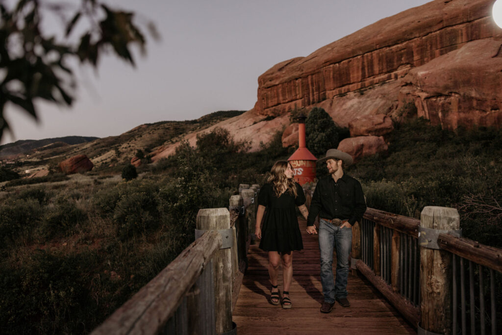 couple walks along path at red rocks park during couples portraits.
