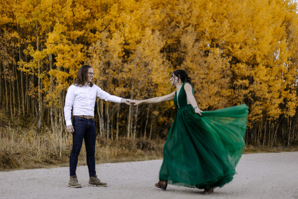 man and woman dance in the road at boreas pass during couples portraits.