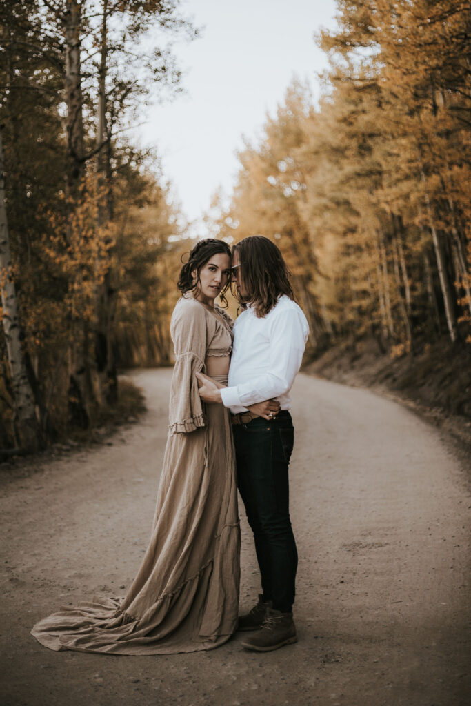 man and woman stand in road and embrace during couples portraits at boreas pass.