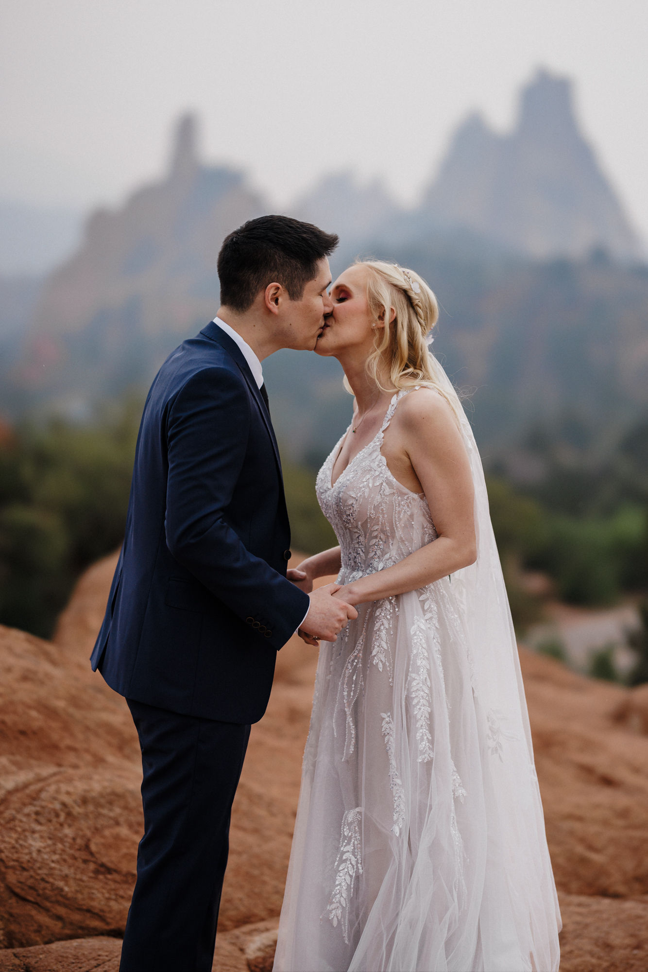 bride and groom kiss in front of colorado mountains at garden of the gods park