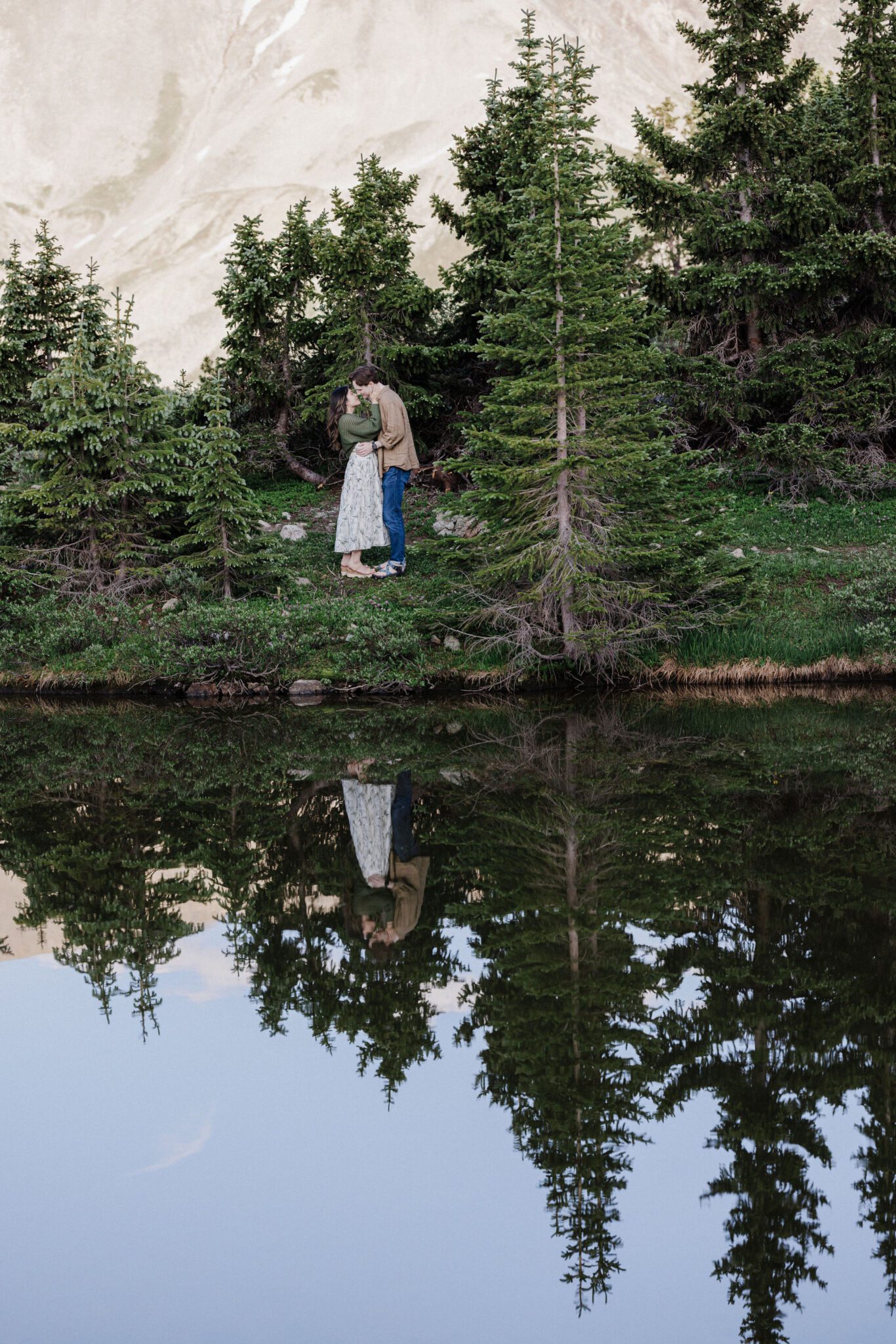 man and woman kiss beside loveland pass lake in colorado