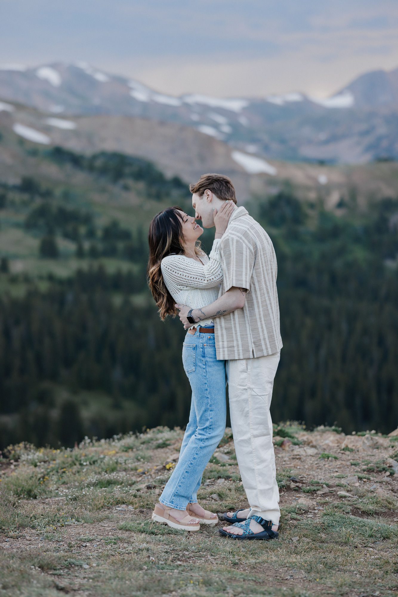 engaged couples kisses in front of the colorado mountains during photo shoot