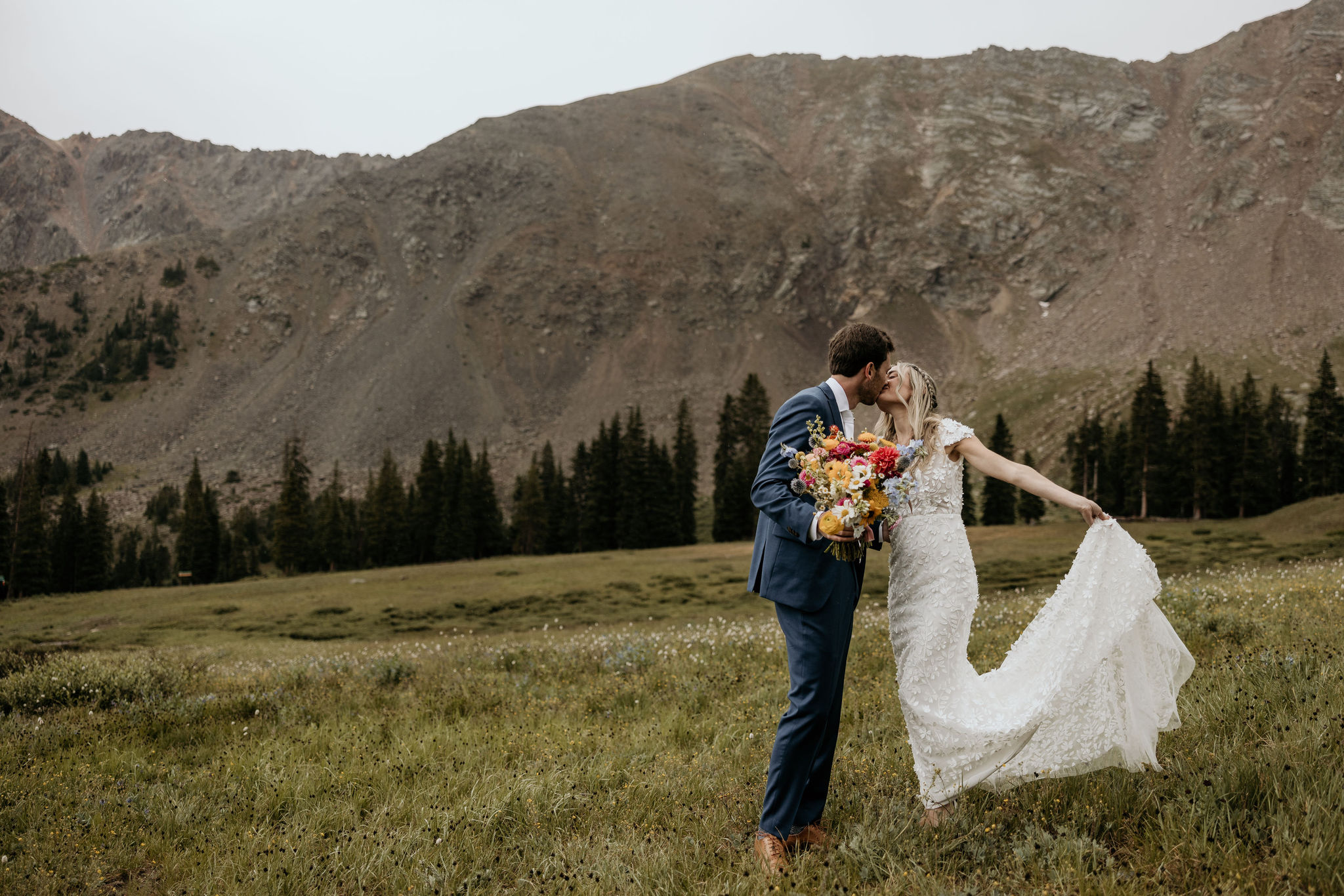 bride and groom pose for colorado elopement photographer at ski resort.