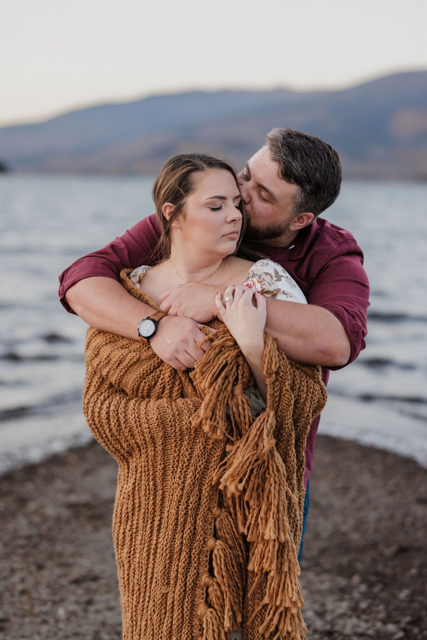 man and woman wrap in blanket during colorado engagement photos