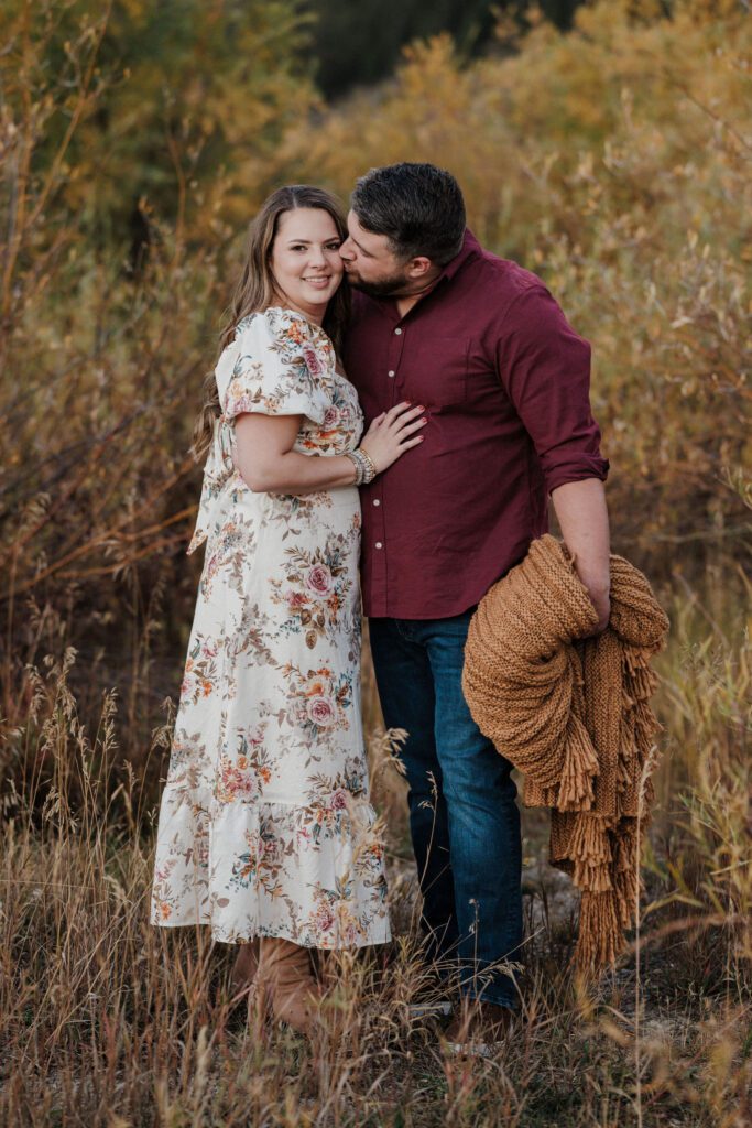 man kisses womans cheek during colorado mountain engagement photos.