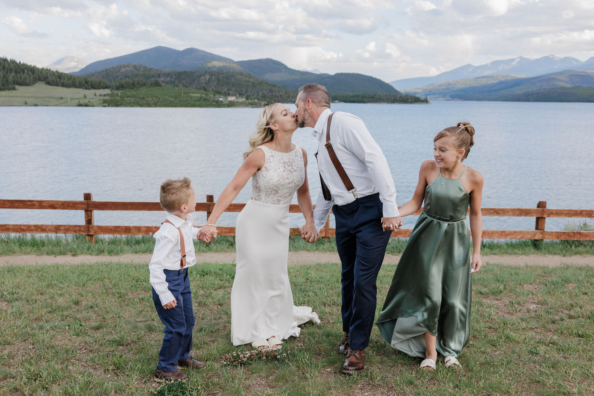 bride, groo, and children hold hands and pose for colorado wedding photogrpaher