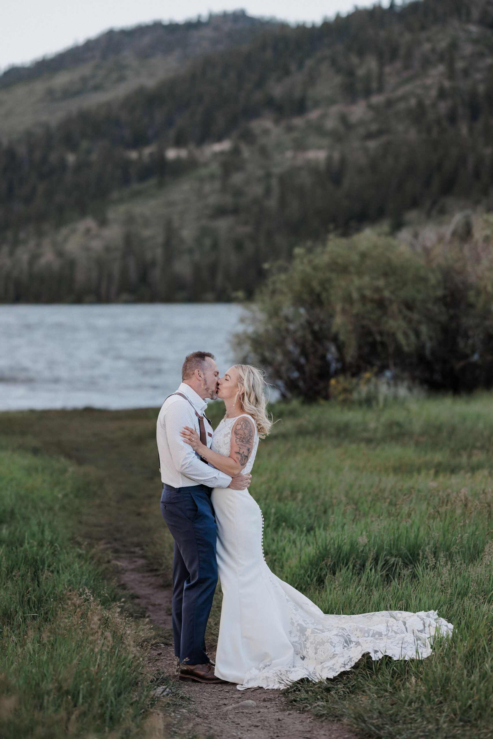 bride and groom kiss beside lake in breckenridge colorado