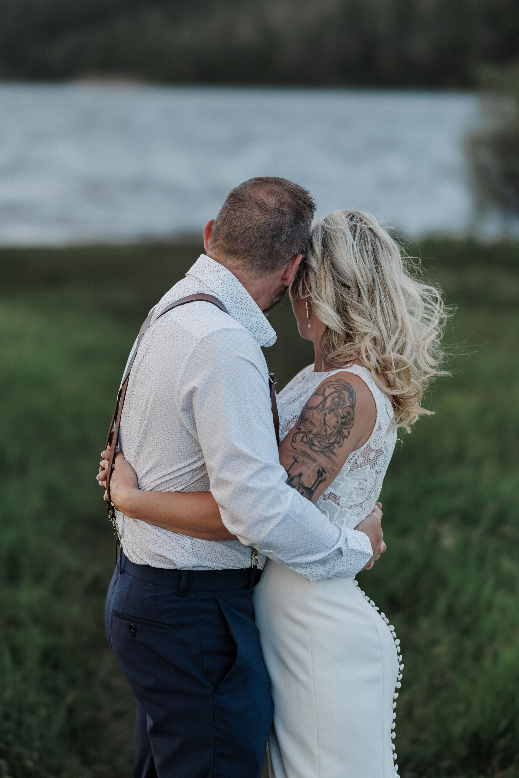 bride and groom pose for colorado micro wedding and elopement photographer at lakeside location