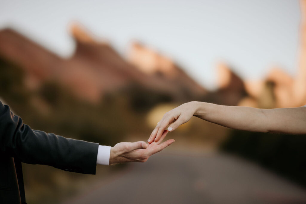 bride and grooms hands reach out and touch each other during colorado micro wedding day.