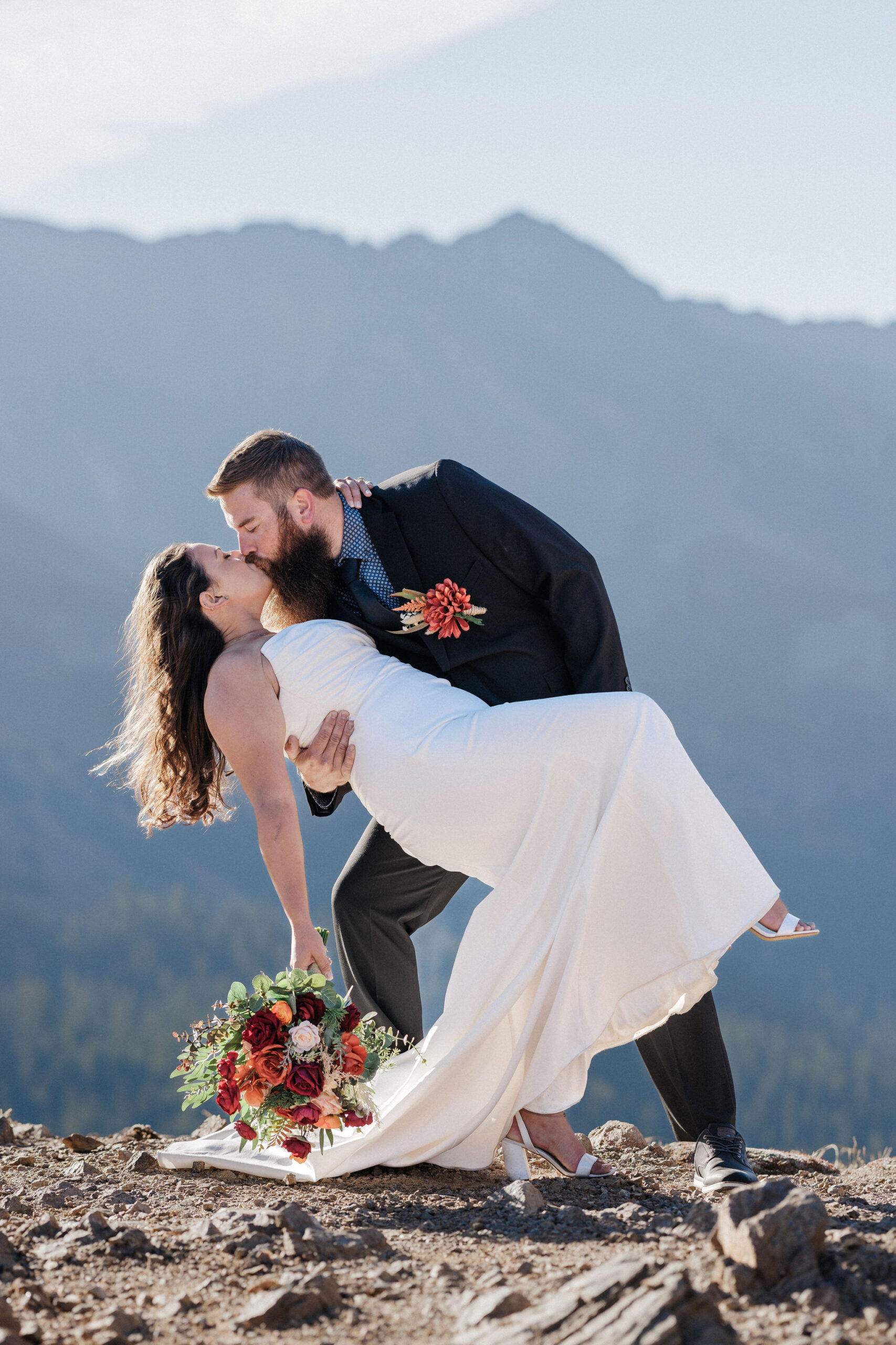 bride and groom kiss at loveland pass during wedding day