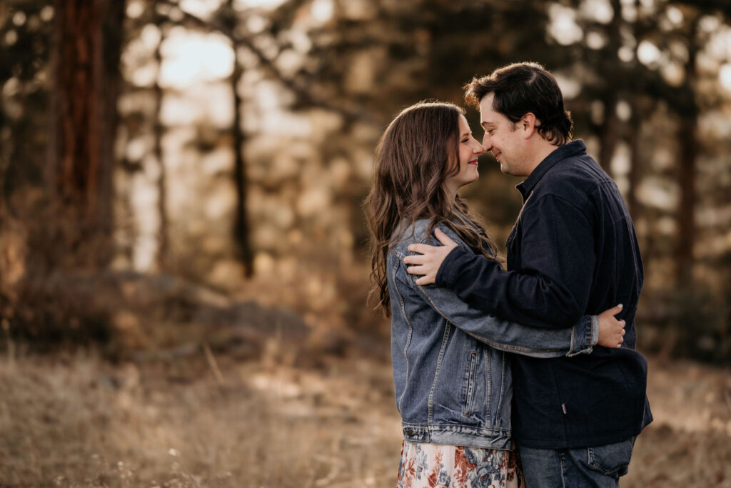 man and woman touch noses during engagement photos in colorado.