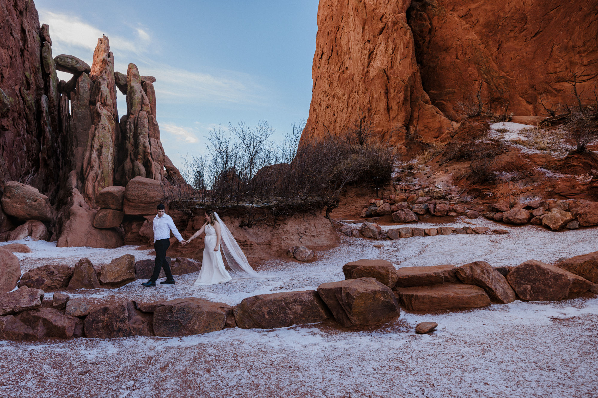 bride and groom walk through garden of the gods park during their colorado elopement day.